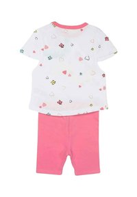 Chemise blanche à manches courtes avec des motifs colorés de cœurs et de papillons, associée à un short rose. En coton doux, design simple.