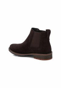 Botas Chelsea de ante marrón con paneles laterales elásticos, puntera redondeada y un tacón bajo apilado. Cuenta con costuras en contraste y suela texturizada.