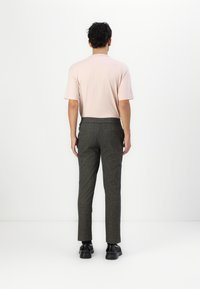 Light pink short-sleeve shirt paired with dark gray, textured tailored pants and black shoes, viewed from the back.