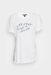 Camiseta blanca de tejido ligero con escote redondo y mangas cortas. En el frente se muestra texto en cursiva color marino: "con mi cabeza en las nubes."