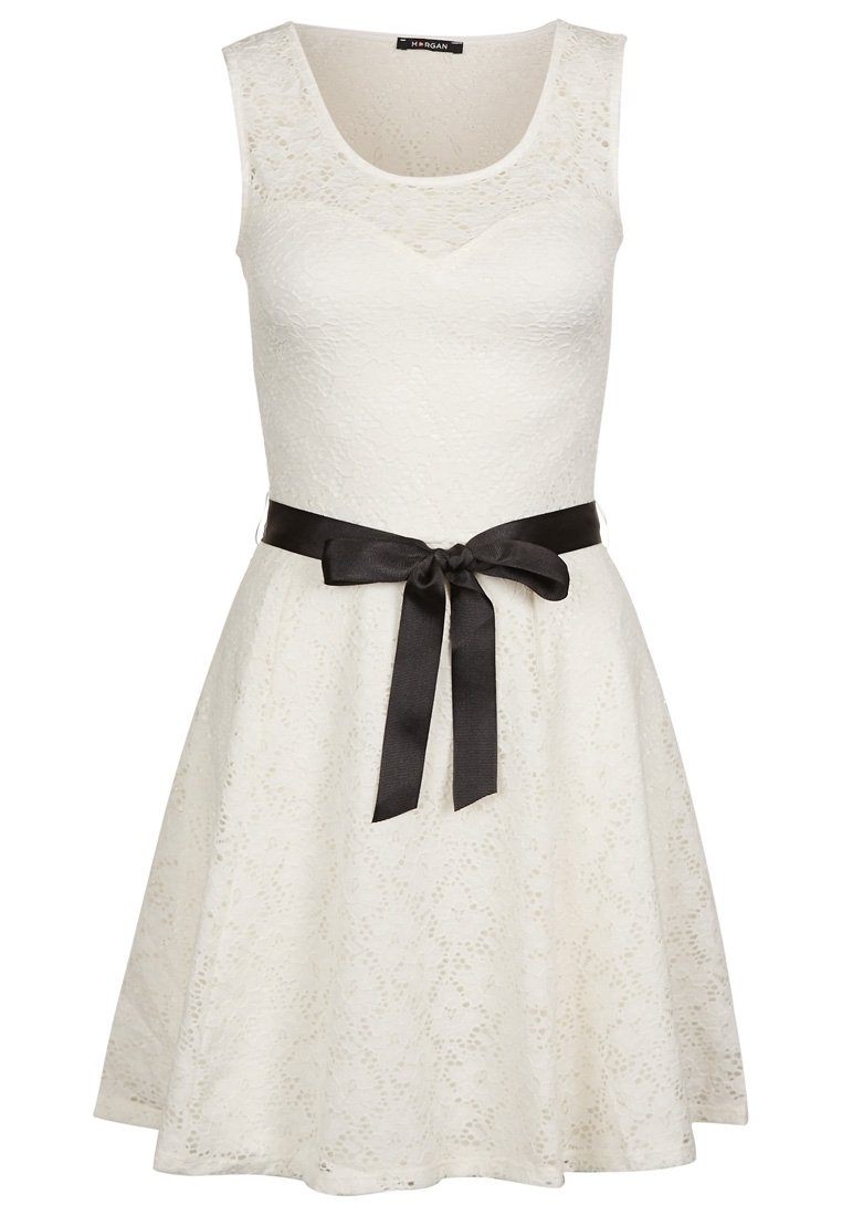 Robe blanche sans manches avec une texture en dentelle, jupe évasée et une ceinture en satin noir nouée à la taille. Encolure arrondie, design longueur genoux.