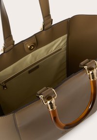 Borsa a spalla marrone con esterno in pelle liscia, hardware dorato e manico lucido color ambra. L'interno presenta una fodera beige e una tasca con zip.