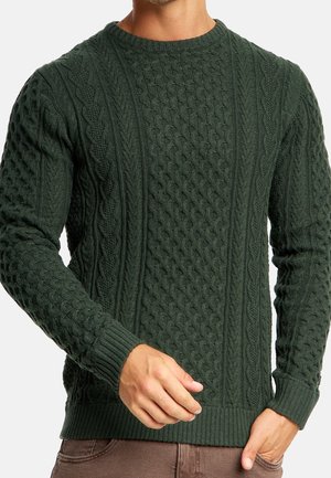 Groene gebreide trui met textuurpatronen, waaronder kabel- en diamantsteken, met geribde manchetten en zoom.