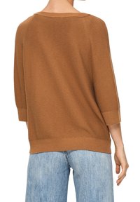 Brunstickad tröja med lös passform, vid halsringning och trekvartslånga ärmar, med ribbad fåll och texturerat mönster.