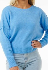 Jasnoniebieski dziergany sweter z prążkowanym ściągaczem na dole i mankietach; charakteryzuje się luźnym krojem i szerokim dekoltem, wykonany z miękkiej mieszanki wełny.