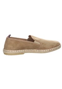 Zapato tipo slip-on en tono marrón claro con parte superior perforada, paneles laterales elásticos y suela envuelta en yute. Presenta una sutil etiqueta tricolor en el talón.