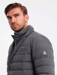 Veste doudoune grise avec un design collier, présentant un quilting horizontal, un devant zippé et une poche poitrine. Logo cousu sur la manche gauche.