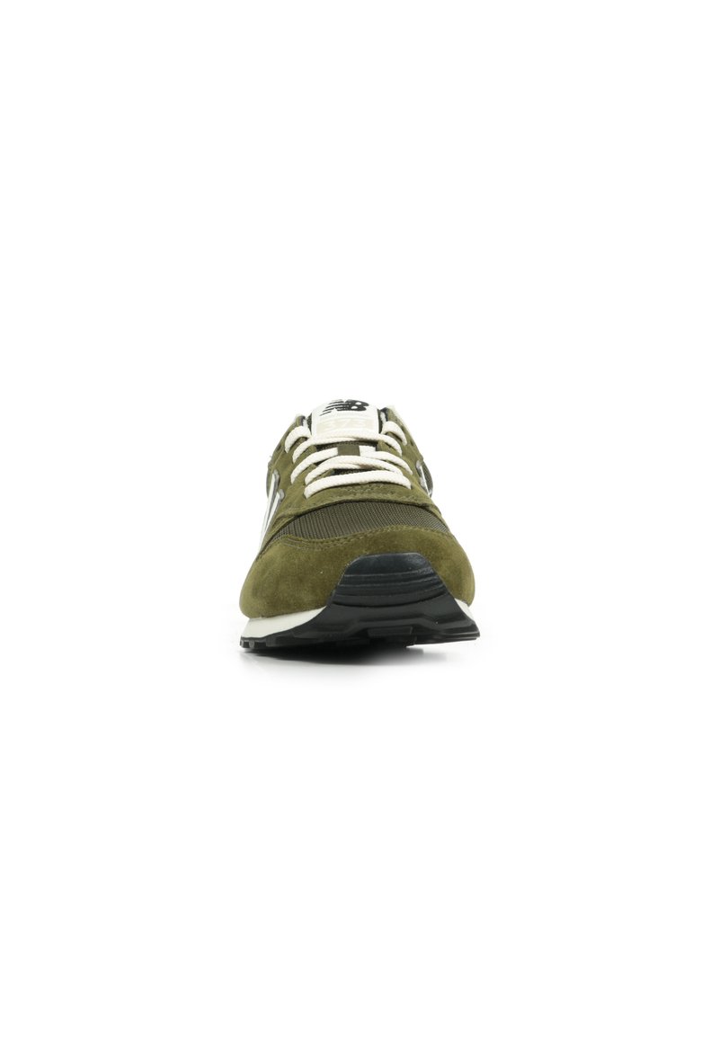 Zapatilla deportiva verde oliva con parte superior de ante y malla, cordones blancos, suela de goma negra y un sutil logotipo en la lengüeta.