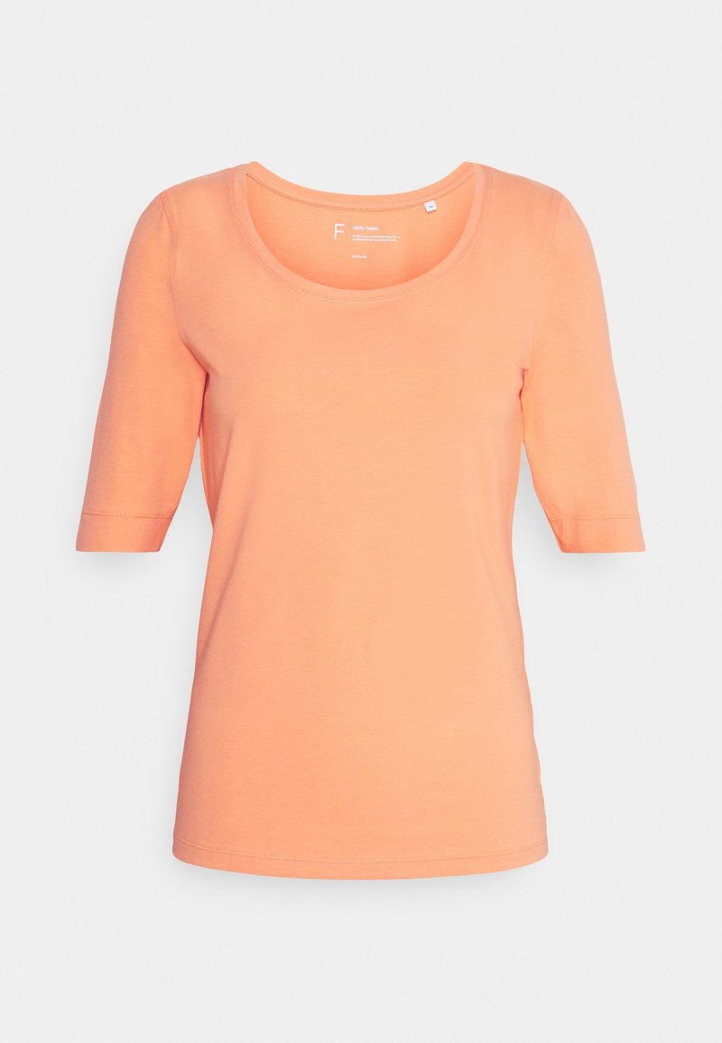 T-shirt à manches courtes et col en scoop en corail orange. Tissu doux et lisse avec une silhouette ajustée et un ourlet droit.