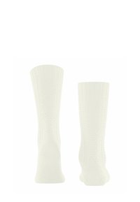 Weiße knielange Socken mit einem gerippten oberen Bund, texturiertem Körper mit Muster und verstärkten Fersen. Hergestellt aus weichem, dehnbarem Material.