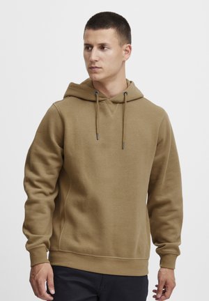 Hoodie marron en tissu doux, doté d'une capuche avec cordon de serrage, de poignets et d'un ourlet côtelés, et d'un petit logo sur la poitrine.