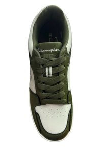Baskets vert olive et blanches avec une tige en cuir lisse, une languette en mesh et des lacets ; présentent des perforations blanches et le logo "Champion" en cursive.