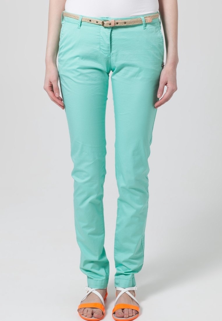 Pantalons slim-fit vert menthe avec une ceinture en cuir texturé marron clair, comportant deux poches avant et une finition en tissu lisse, associés à des sandales orange.