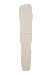 Pantaloni bej, cu picioare largi, realizați dintr-un material cu detalii de patchwork destrămat pe coapse. Buzunar posterior solid, cu un brâu standard și închidere cu nasture.