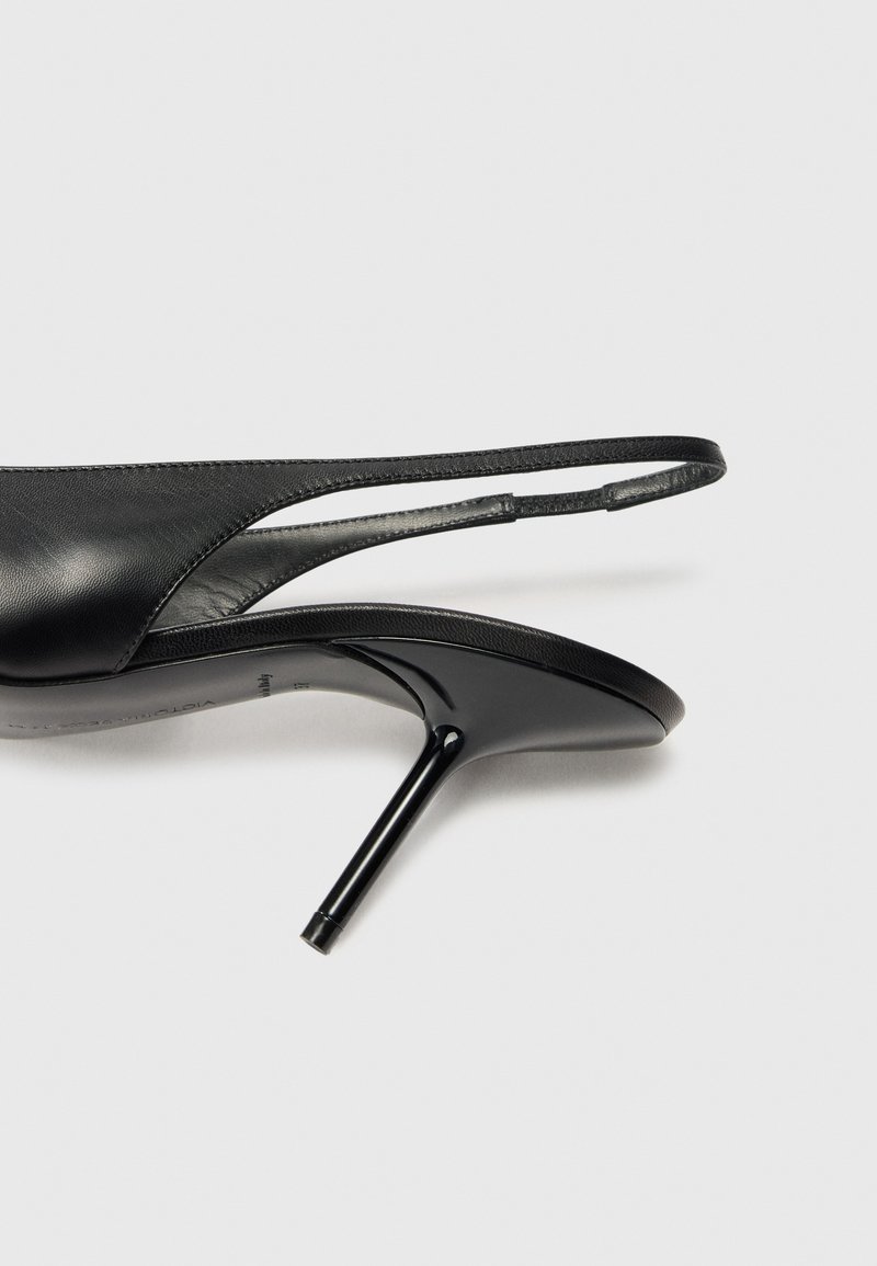 Sort læder højhælede slingback sko med spids tå, slank hæl og minimalistisk design med en glat tekstur og strømlinede linjer.