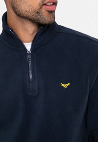Pullover in fleece navy con zip a quarto, morbido al tatto e con un piccolo logo giallo ricamato sul petto.