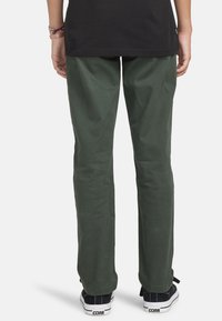 Groene katoenen broek met een rechte pijp. Heeft een gladde textuur en een nette afwerking. Gekocht met zwarte sneakers.