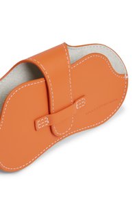 Πορτοκαλί δερμάτινη θήκη με λευκή ραφή και κλείσιμο με πόρπη, με καμπύλο σχέδιο και μαλακή, υφασμάτινη εσωτερική επένδυση.