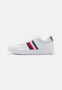 Białe sneakersy wykonane z syntetycznej skóry z teksturowaną siateczką. Posiadają czerwone i granatowe paski po bokach, gumową podeszwę oraz sznurowany styl.