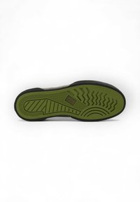 Semelle de chaussure avec un contour noir et un fond en caoutchouc vert. Présente un motif de semelle détaillé et un logo au niveau de la semelle intermédiaire.