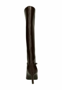 Hoge, donkerbruine leren laars met hoge hak en slanke stiletto-hak, voorzien van een enkelbandje met gesp, van achteren gefotografeerd op een witte achtergrond.