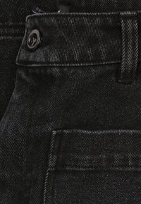 Zwarte denim jeans met een gestructureerde stof, een metalen knop en een voorvak met een klassiek ontwerpdetail.