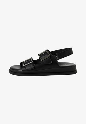 Čierna kožená sandála s dvoma nastaviteľnými striebornými prackami, otvoreným prstom, zadným pásikom a plochou gumovou podrážkou. Hladký povrch po celom obvode.