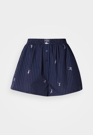 Navy blue cotton shorts with white vertical stripes, featuring small illustrated figures and a button front, with an elastic waistband.