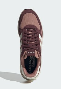 Bordová sportovní obuv se síťovinovým a semišovým svrškem, bílé akcentové pruhy, šněrovací design a měkká vložka označená "Cloudfoam Comfort."