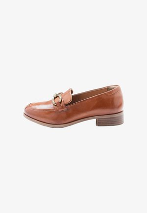 Mocasín de cuero marrón con tacón bajo apilado y hebilla metálica decorativa dorada en la parte frontal, visto desde un lado.