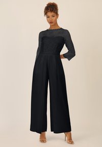 Zwarte jumpsuit met een kanten lijfje, drie kwart mouwen, een recht ontwerp en een vloeiende textuur.