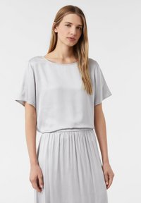 Hellgraues Satin-Kleid mit lockerer Passform, kurzen Ärmeln und rundem Ausschnitt. Die Taille verfügt über ein elastisches Band für ein gerafftes Design.
