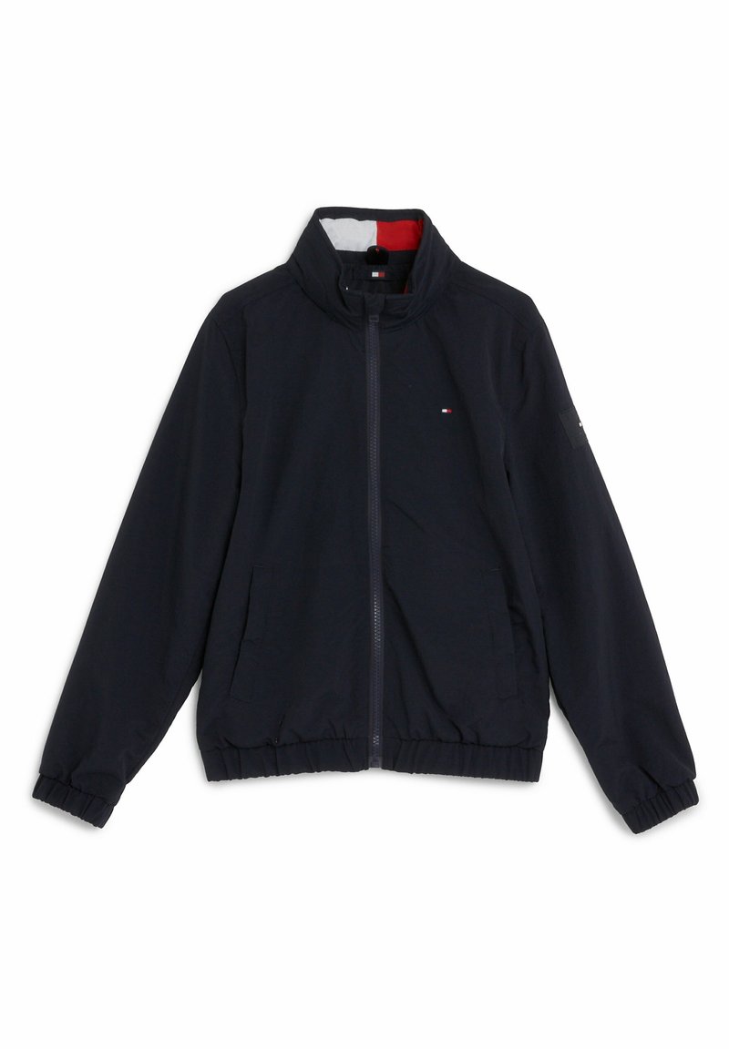 Marinblå lättviktsjacka med ståkrage, framzipper, elastiska ärmslut och midja. Har sidofickor och diskret logotypdetalj.