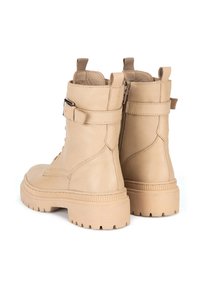 Béžové kožené kotníkové boty s texturovaným povrchem, se bočním zipem, detailním páskem a robustní gumovou podrážkou se drážkami.