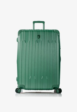Hartschalenkoffer in Grün mit vertikalen Rillen, einem teleskopierbaren Griff, vier multidirektionalen Rollen und einem Logo auf der Vorderseite.