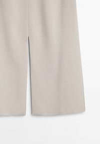 Light grey wide-leg trousers made of smooth fabric, featuring side slits at the hem for added movement and breathability.