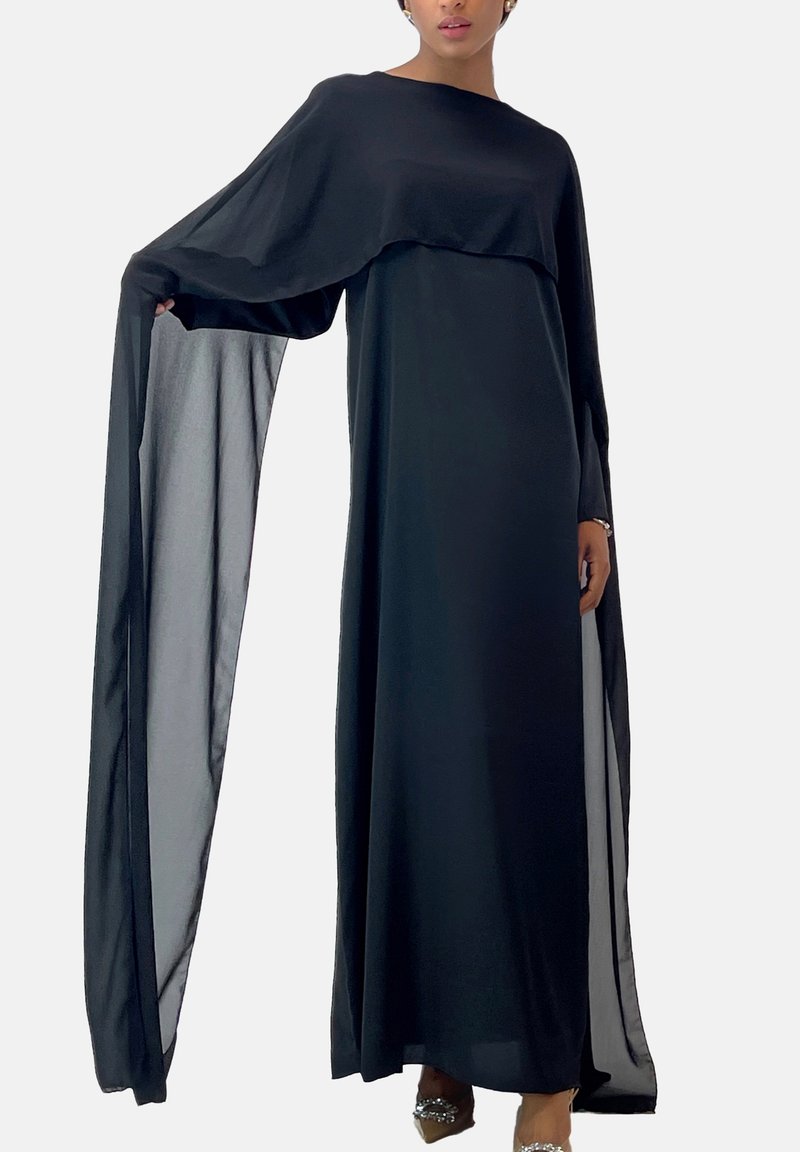 Abito lungo nero con maniche lunghe a strati e silhouette fluida. Realizzato in tessuto leggero con una texture liscia e spacchi laterali.