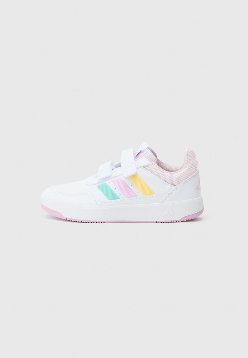 Zapatilla deportiva blanca con detalles de malla, con franjas en azul pastel, amarillo y rosa. Incluye tiras ajustables de Velcro y una suela rosa.