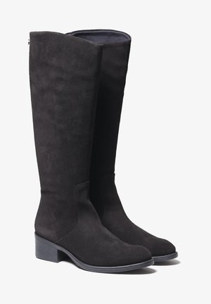 Bottes hautes jusqu'au genou en daim noir avec un design élégant, présentant un talon discret et une texture lisse. Aucun élément métallique ni motif visible.