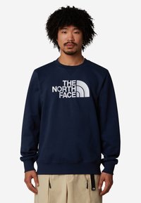 Felpa blu navy, in misto cotone, con collo a giro, polsini e orlo a costine, caratterizzata da un logo bianco prominente sulla parte frontale.
