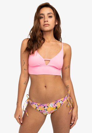 Růžový bikiny top s V-krkem, v kombinaci s květinovými spodními díly s žlutými a fialovými akcenty a bočními šňůrkami.