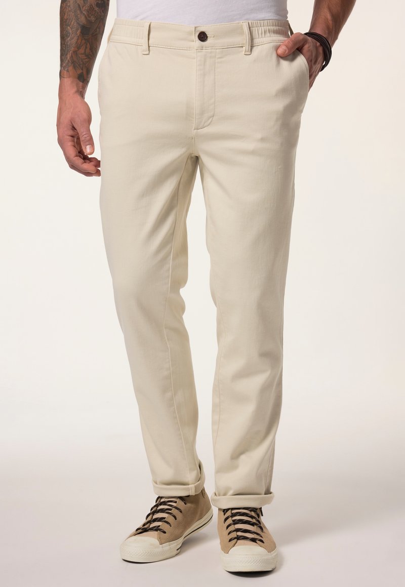 Beige chino's met een slim fit, gemaakt van een katoenmix. Voorzien van een knoopsluiting en opgerolde mouwen. Gekleed met lichtbruine sneakers.