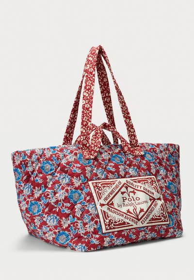 Κόκκινη καπιτονέ τσάντα ώμου με μπλε και λευκό floral σχέδιο, μακριές λαβές και λογότυπο Polo by Ralph Lauren στο μπροστινό μέρος.