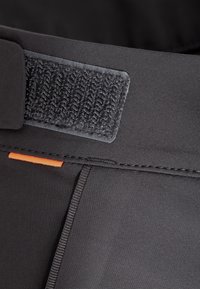 Mustahdoth black fabric waistband with grey velcro closure, featuring an orange accent stitch and smooth texture. Designed for flexibility and comfort.