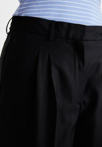 DORA MERLA EXTRA WIDE - Pantalones - black
