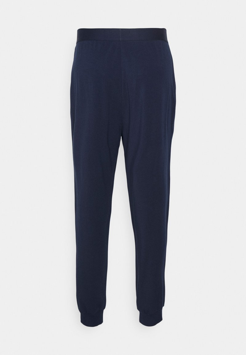 Pantaloni blu navy realizzati in tessuto morbido, con una cintura elastica e polsini aderenti alle caviglie. Design minimalista, senza motivi visibili.