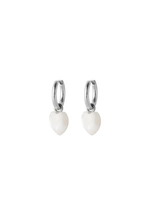 Silver hoop earrings each with a small white heart-shaped charm dangling below on a plain white background.