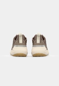 Brown suede and mesh athletic shoes, featuring a textured design, light grey accents, and a cream-colored sole with a patterned tread.