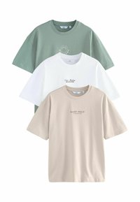 Pakke med tre T-shirts: en grøn med et rundt print, en hvid med tekst, og en beige med kontrasterende tekst. Alle har korte ærmer.