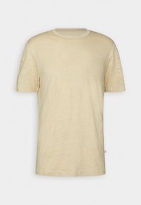 T-shirt beige à manches courtes avec col rond, en tissu léger et texturé, présenté sur un fond blanc uni.
